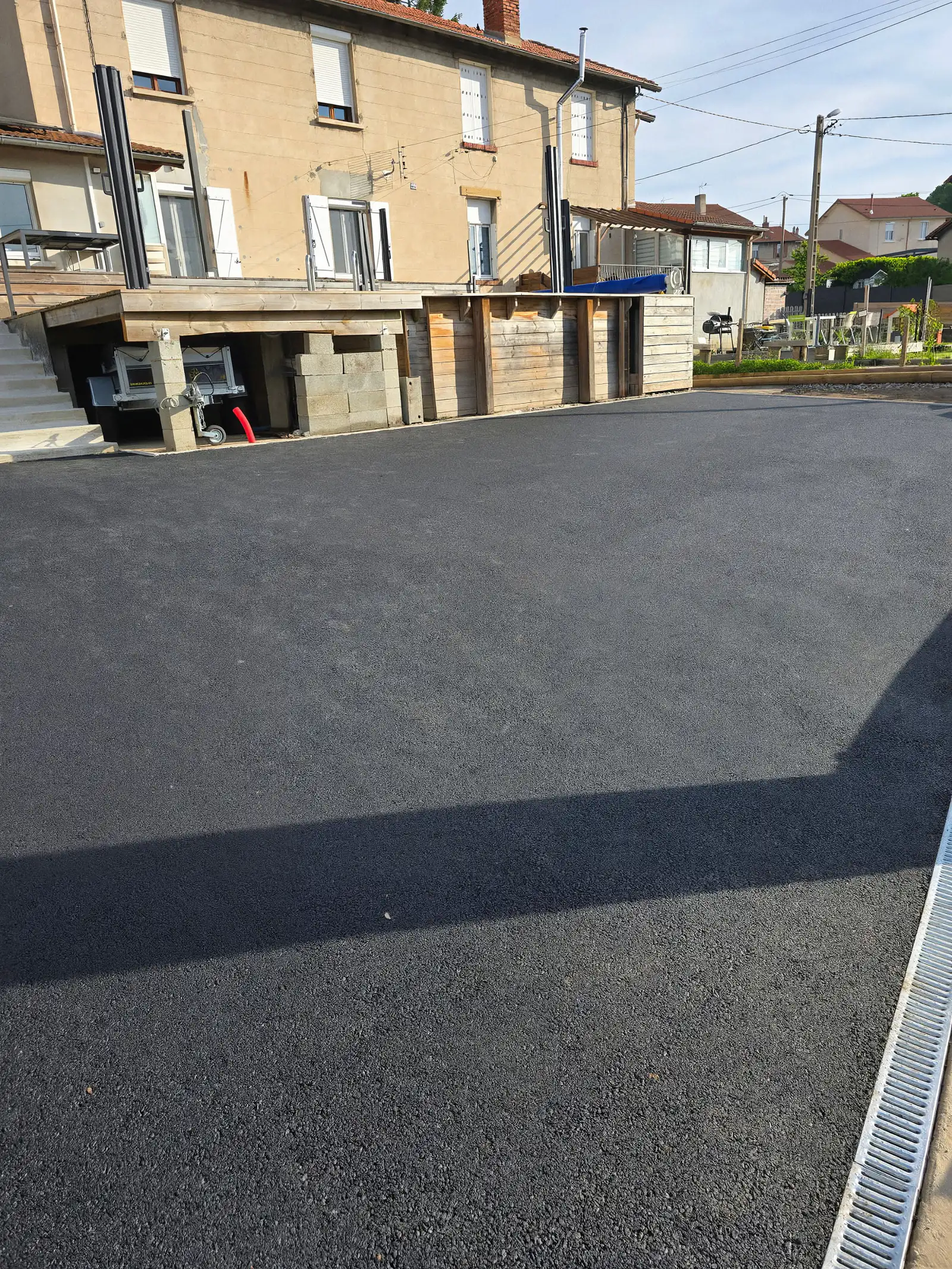 Cour de maison de ville entièrement revêtue d'enrobé neuf, caniveau à grille en bordure